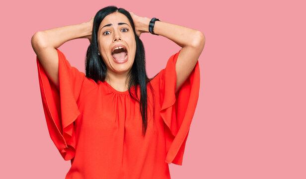 Beautiful young woman wearing casual clothes crazy and scared with hands on head, afraid and surprised of shock with open mouth