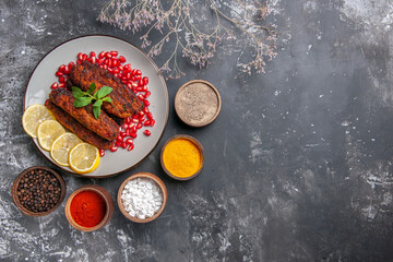 Fototapeta na wymiar top view long meat cutlets with lemon and pomegranates on a grey background dish meal roll