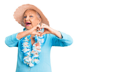 Senior beautiful woman with blue eyes and grey hair wearing summer hat and hawaiian lei smiling in...