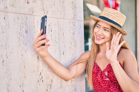 Young caucasian tourist girl smiling happy doing video call using smartphone at the city.