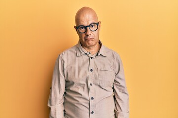 Middle age bald man wearing casual clothes and glasses depressed and worry for distress, crying angry and afraid. sad expression.