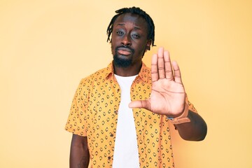 Young african american man with braids wearing casual clothes doing stop sing with palm of the...
