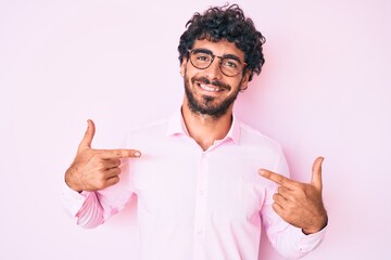 Handsome young man with curly hair and bear wearing business shirt and glasses looking confident...