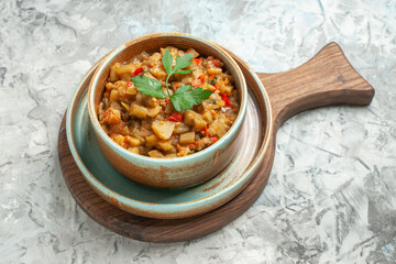bottom view roasted eggplant salad in bowl on cutting board on grey background