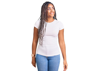 Fototapeta premium Young african american woman with braids wearing casual clothes looking away to side with smile on face, natural expression. laughing confident.