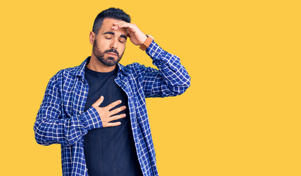 Young hispanic man wearing casual clothes touching forehead for illness and fever, flu and cold, virus sick