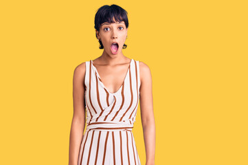 Young brunette woman with short hair wearing summer outfit afraid and shocked with surprise...