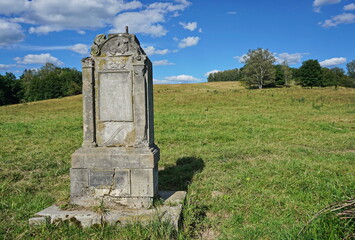 Old ruined stone monument at a meadow.