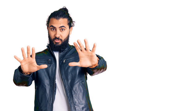 Young arab man wearing casual leather jacket doing stop gesture with hands palms, angry and frustration expression