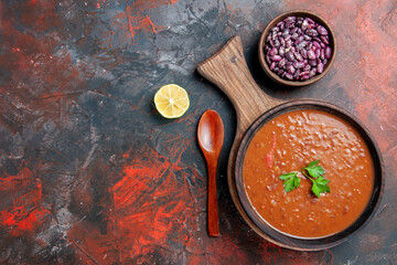 Horizontal view of tomato soup fallen oil bottle beans on cutting board on a mixed color background