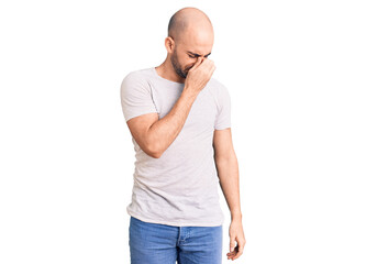 Young handsome man wearing casual t shirt tired rubbing nose and eyes feeling fatigue and headache. stress and frustration concept.