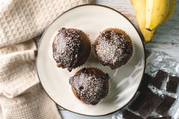 Top view flat lay on chocolate muffin cakes with banana on the table