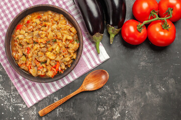 top view roasted eggplant salad in bowl wooden spoon tomatoes eggplants on dark background free space