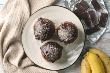Top view flat lay on chocolate muffin cakes with banana on the table