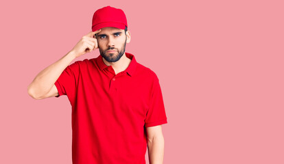 Young handsome man with beard wearing delivery uniform pointing unhappy to pimple on forehead, ugly infection of blackhead. acne and skin problem