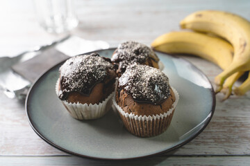 Close up on chocolate muffin cakes with banana in a plate on table