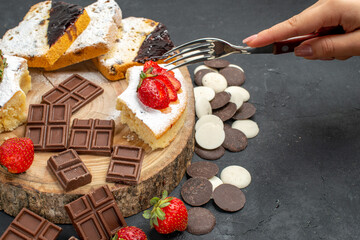 front view cake slices with chocolate bars and cookies on dark background pie sweet fruit