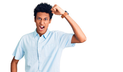 Fototapeta premium Young african american man wearing casual clothes angry and mad raising fist frustrated and furious while shouting with anger. rage and aggressive concept.