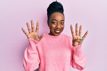 Young african american woman wearing casual winter sweater showing and pointing up with fingers...