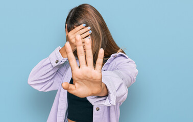 Teenager caucasian girl wearing casual clothes covering eyes with hands and doing stop gesture with...