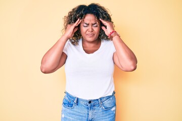 Young african american plus size woman wearing casual white tshirt with hand on head for pain in head because stress. suffering migraine.