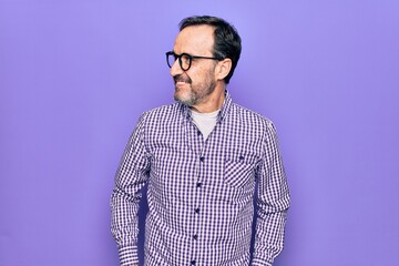 Middle age handsome man wearing casual shirt and glasses over isolated white background looking to side, relax profile pose with natural face and confident smile.