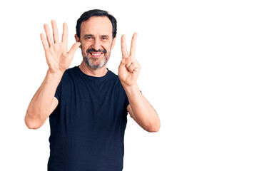 Middle age handsome man wearing casual t-shirt showing and pointing up with fingers number seven while smiling confident and happy.