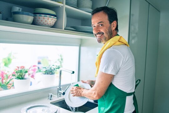 Middle Age Man With Beard Smiling Happy Washing Dishes At Home