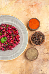 Plakat top view salad on a ceramic plate with black pepper ground black pepper turmeric on a wooden background with copy place