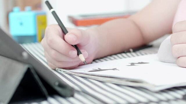 Asian boy lying and drawing at home.