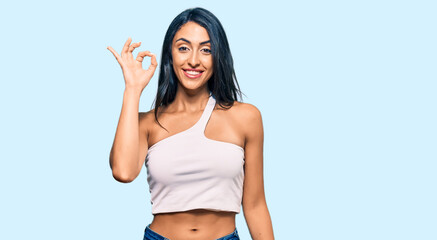Obraz na płótnie Canvas Beautiful hispanic woman wearing casual clothes smiling positive doing ok sign with hand and fingers. successful expression.