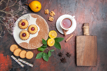 top view little cookies with cup of tea on dark background sugar biscuit cake sweet