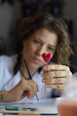 Making heart shape from gumpaste for valentines's. Cake decoration process. Baker uses the tools...