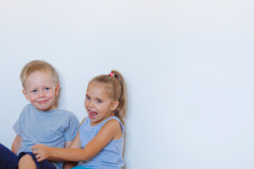 a boy and a girl are sitting on the floor. Children together at home