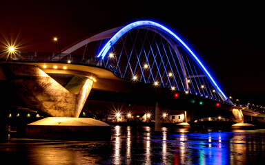 Lowry Avenue Bridge colored blue at dusk with Minneapolis Skyline behind