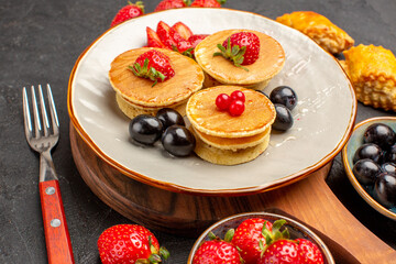 front view delicious pancakes with fruits on a dark background cake fruit sweet pie