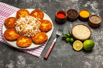 half-top view tasty fried cutlets with rice and seasonings on dark background meat rissole food