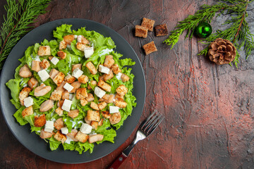 top view caesar salad on oval plate fork dried crust on dark red table free space
