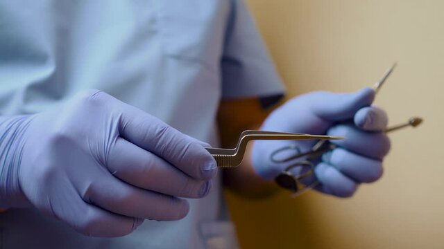 The instrument in the hands of the doctor. Close up of unrecognizable hands of medical doctor, surgical scissors, professional surgeon operation