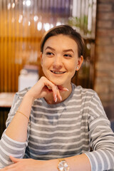 City coffee house portrait of a young chic woman with pixie cut