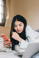 Young adult single woman using smartphone in the moring for social message app chat with friend