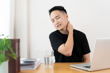 Fototapeta premium Asian young man having a heath problem from working with out relaxing, office syndrome problem.