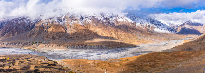 Serene Landscape of Spiti river valley with agriculture fields and snow capped mountains in...