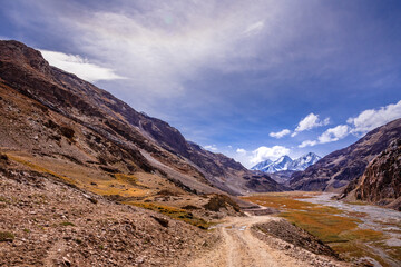 Beautiful view of cold desert arid landscape enroute off road connecting Kaza town with Chandratal Lake passing through Kunnzum Pass in Lahaul Spiti region of Himalayas in Himachal Pradesh, India.