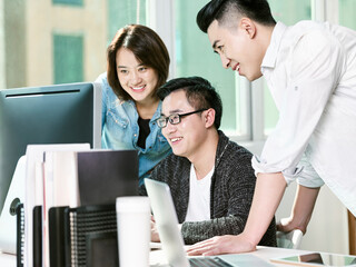 team of three asian business people working together in office