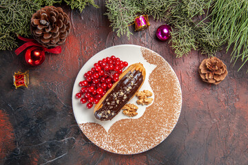 top view yummy choco eclairs with red berries on the dark background cake pie dessert sweet
