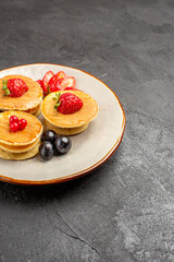 front view yummy pancakes little formed with fruits on a grey background fruit cake pie