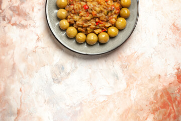 top view roasted eggplant salad and pickled plums on plate on nude background with free space