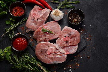 Raw fresh  ossobuco meat on a table with spices and herbs.. Ingredients for Italian stew