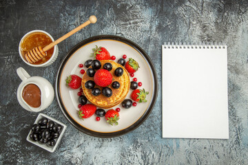 Fototapeta na wymiar top view delicious pancakes with honey and fruits on a light background fruit cake sweet